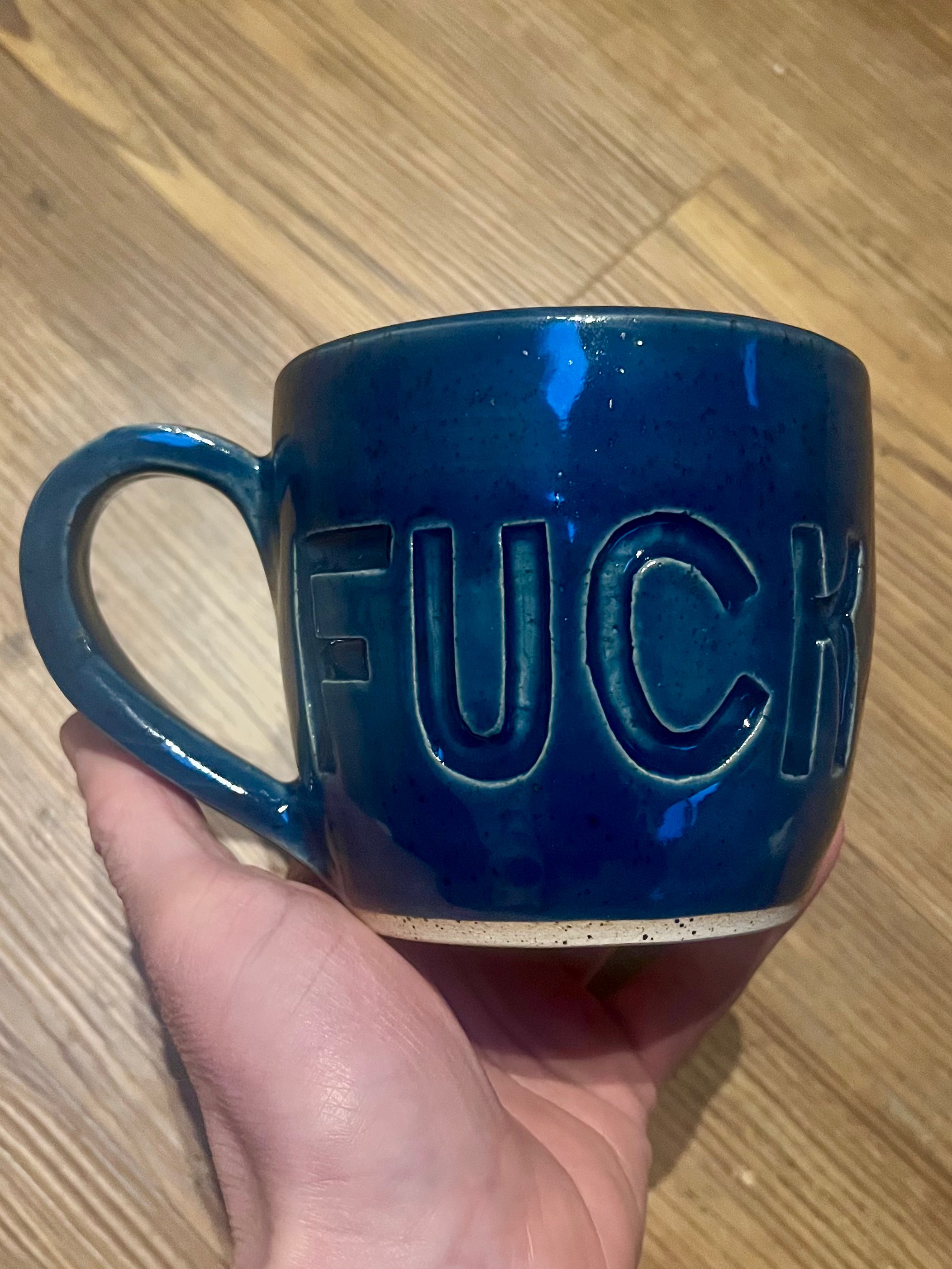 Blue mug with fuck carved into it