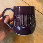 Purple mug with fuck carved into it.