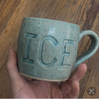 Handthrown aqua mug with fuck ice carved into it.