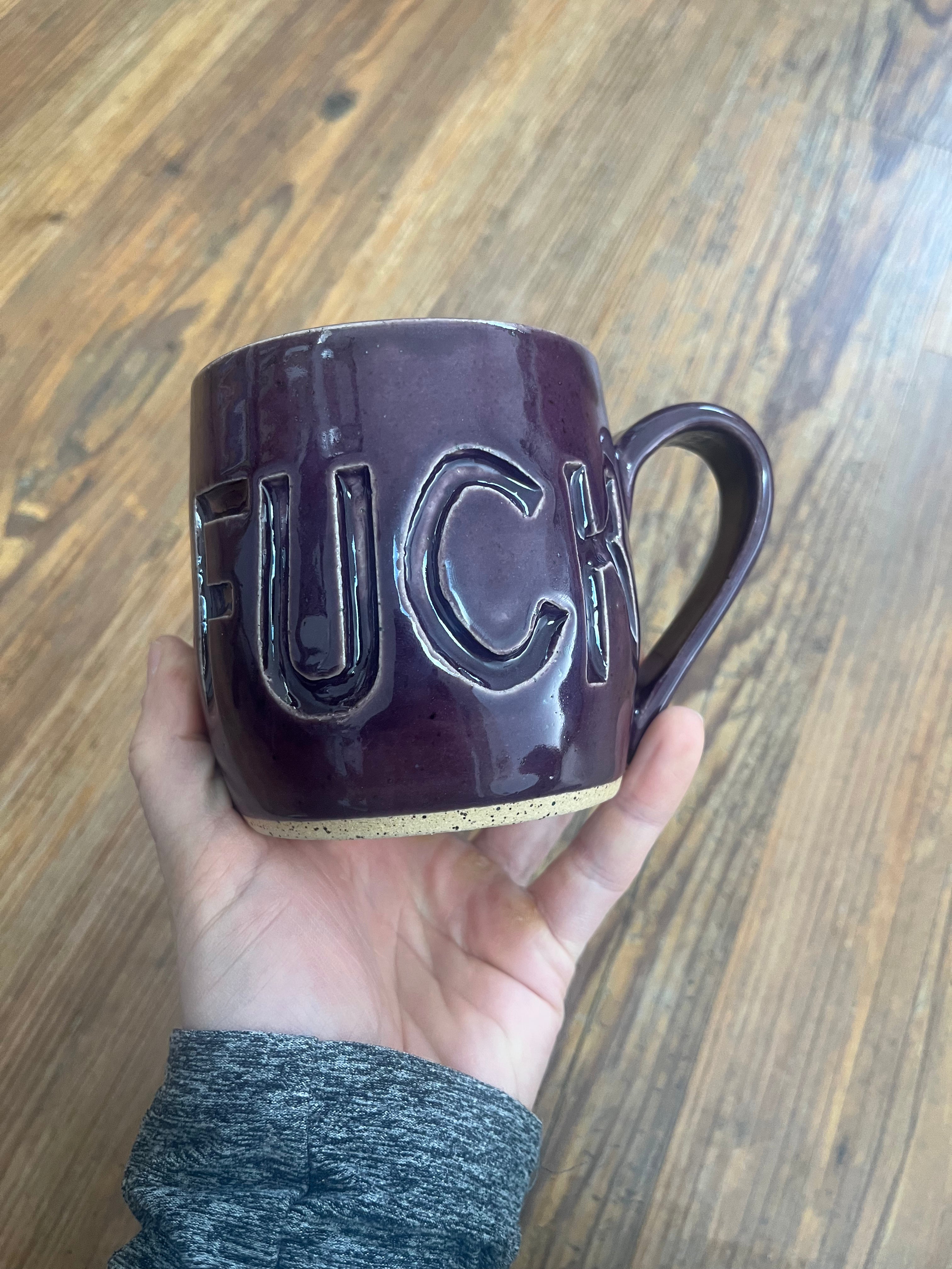 Handthrown purple ceramic mug with fuck carved into it