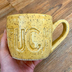 Yellow mug with fuck carved into it