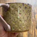 A video rotating around a mug with "f*ck this sh*t stamped in diagonal stripes in a rainbow of colors
