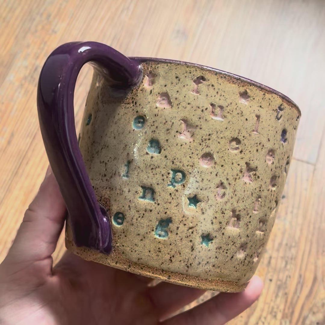 A video rotating around a mug with "take the fucking leap" stamped in diagonal stripes with a purple handle