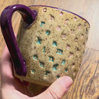 A video rotating around a mug with "chase your fucking dreams" stamped in diagonal stripes with a purple handle