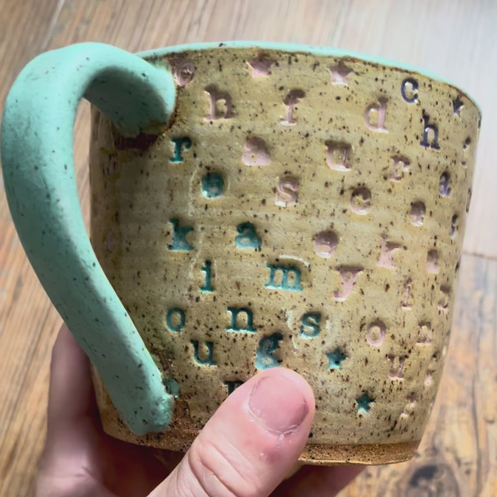 a video rotating around a mug with "chase your fucking dreams" stamped in diagonal stripes with a seaglass colored handle