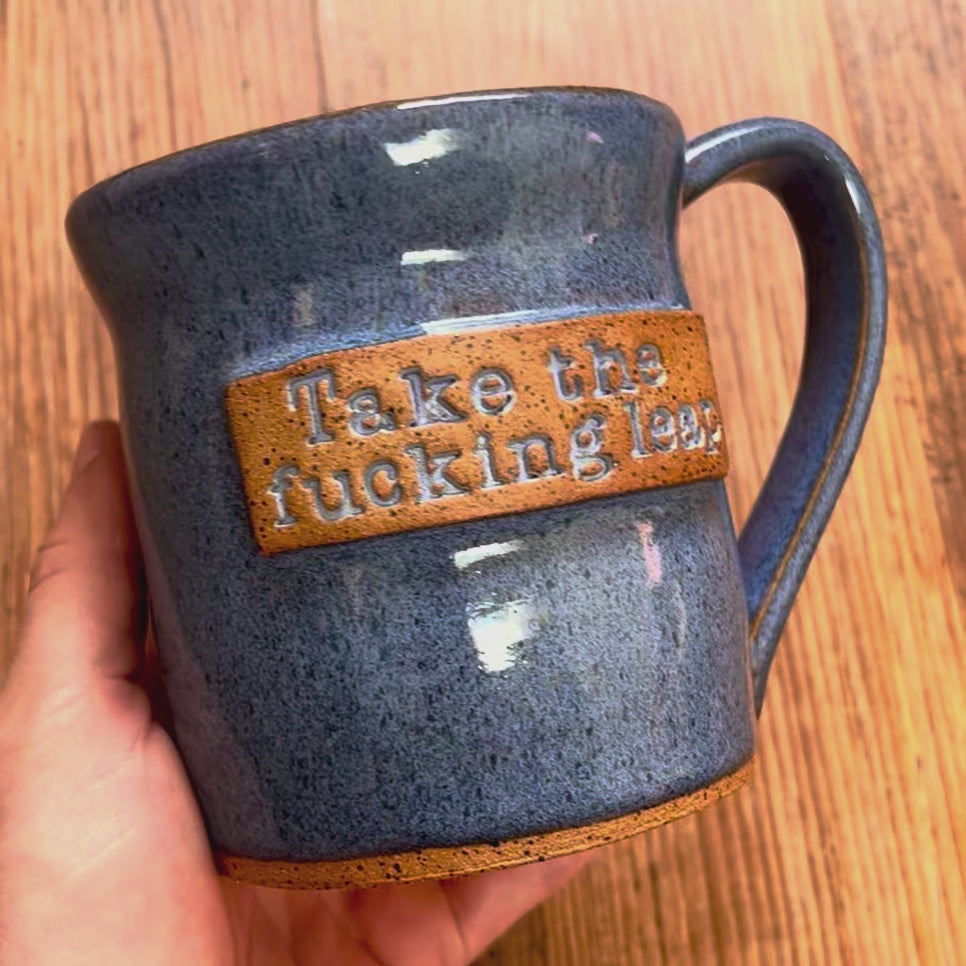 A video rotating around a blue  mug featuring the phrase "Take the fucking leap"